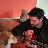 Dave Earley with a guitar and a very patient dog